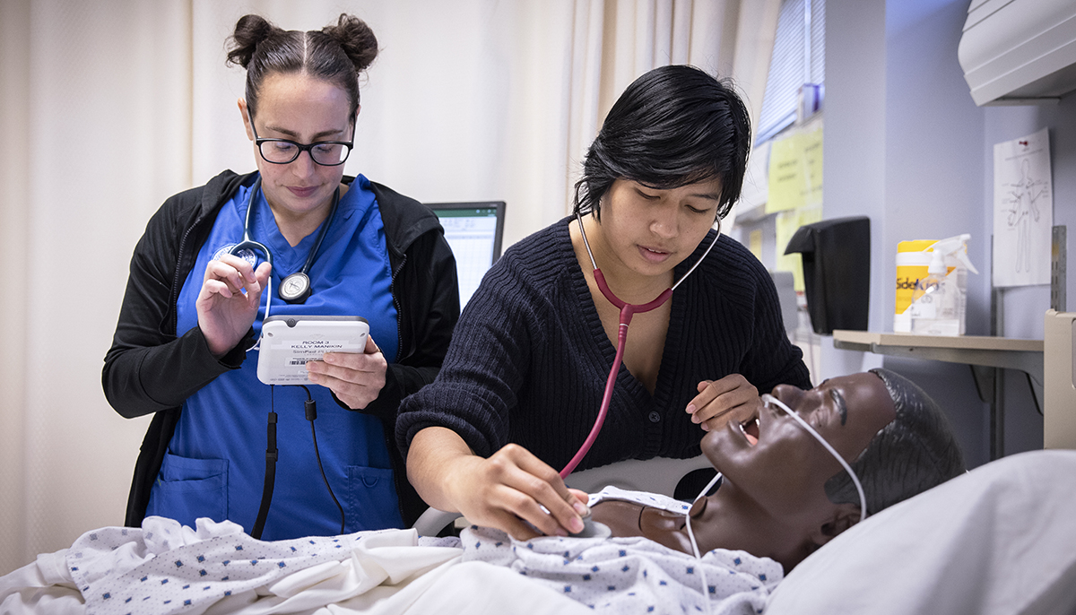 nursing students with stethoscope andmannequibn