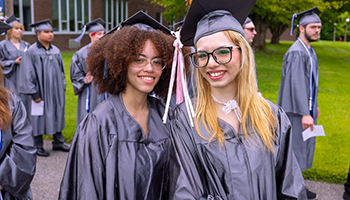 two young owmen smiling at graduation 2024