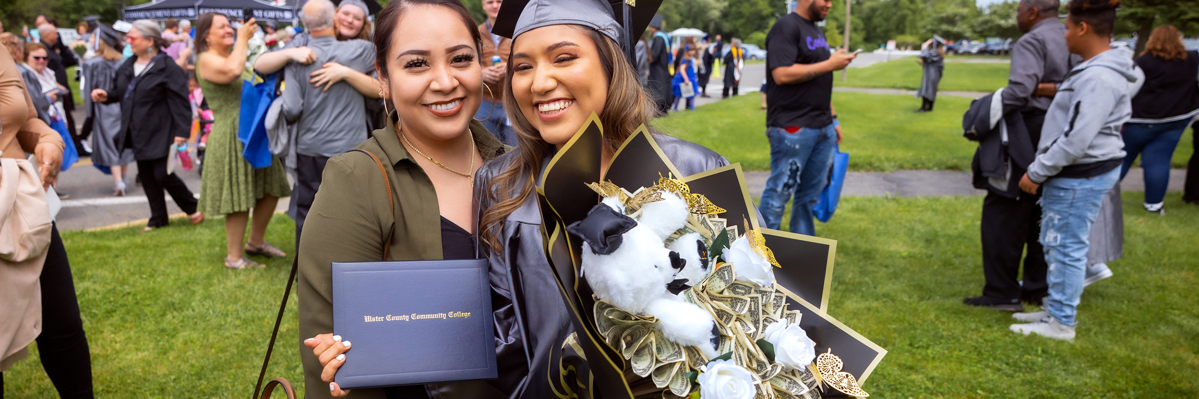 graduate with bouquet of cash and family member at suny ulster 2024 commencement