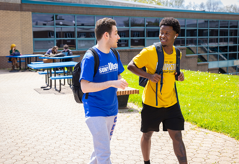 two young males talking happily wearing SUNY Ulster t-shirts