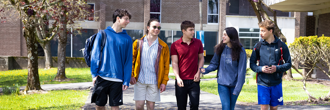 5 students walking and talking outside on SUNY Ulster campus