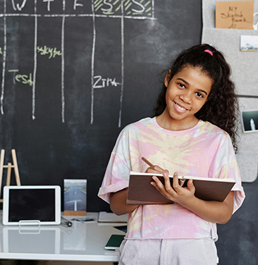 young girl with chalkboard and notebook