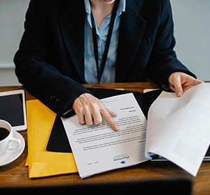 person in suit pointing at paperwork