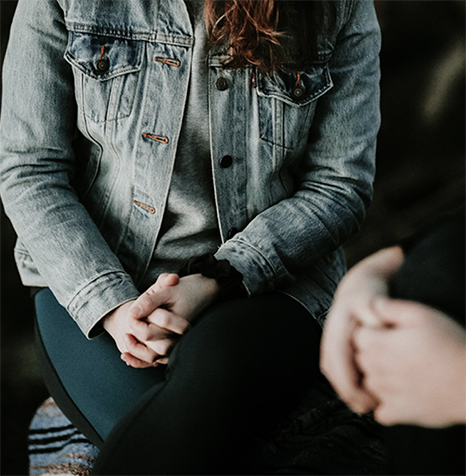 person with clenched hands and denim jacket