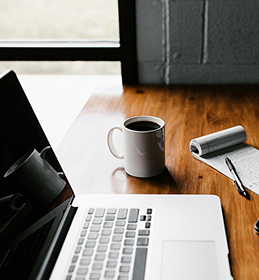 computer on desk with coffee cup 