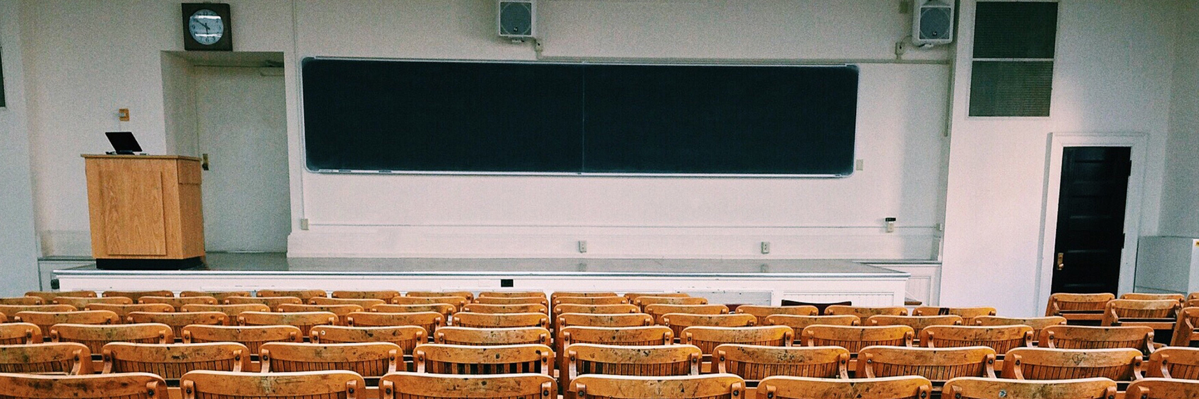 classroom with chalkboard and wooden seats