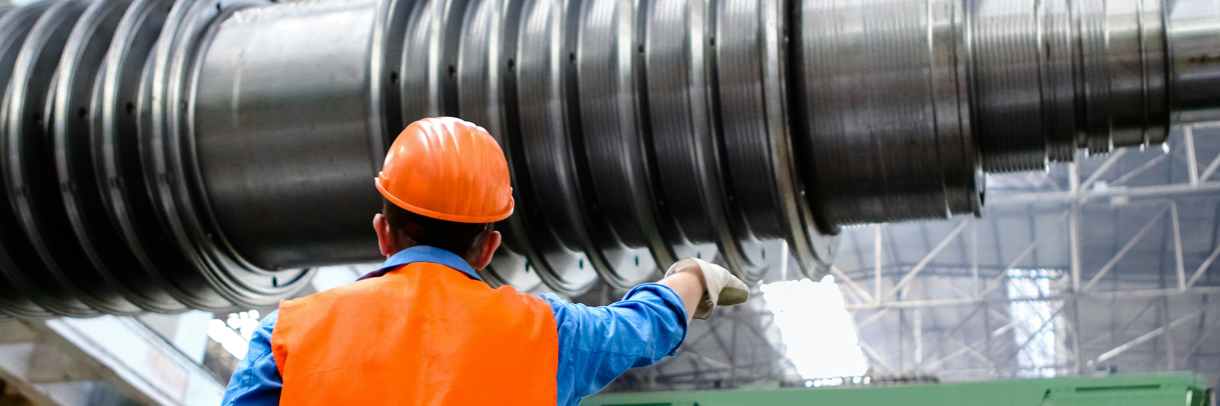 person in safety gear with large machine parts