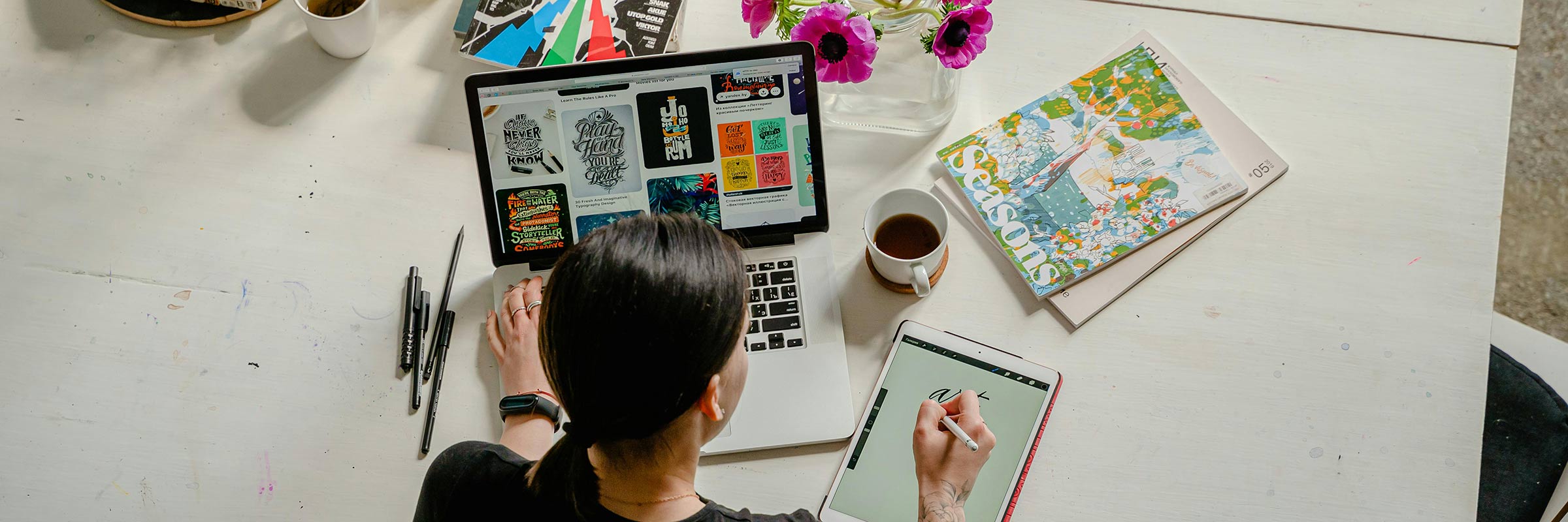 person at desk with devices and coffee