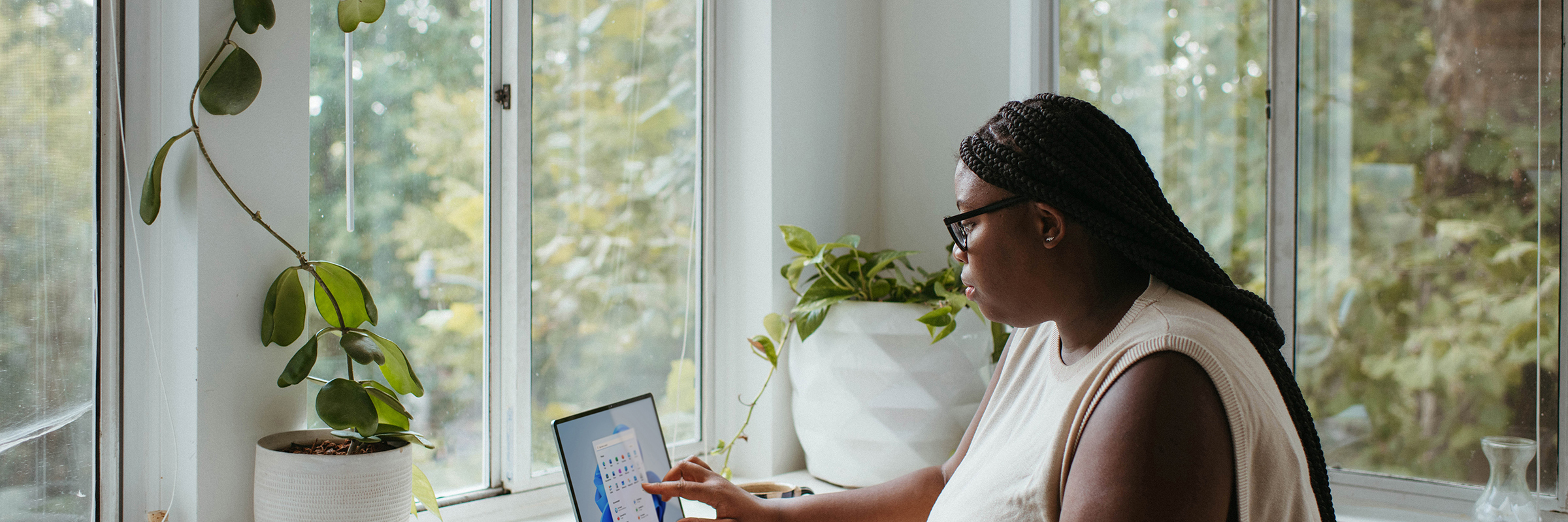 young women alone at computer near window in calm white room