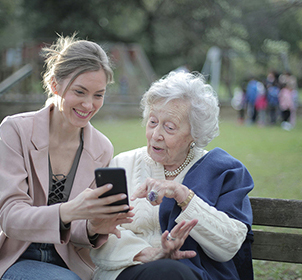 woman helping older woman with phone