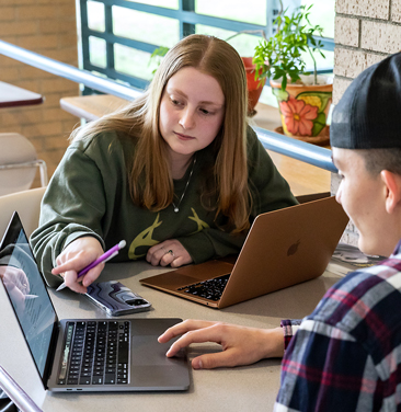 students pointing at laptop screen