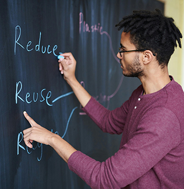 young man writing on blackboard