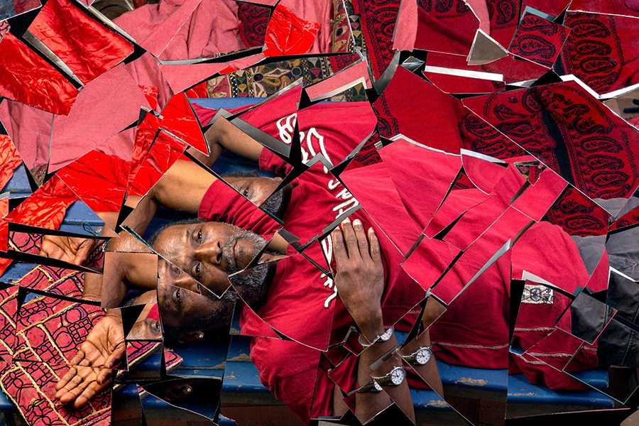 black man relaxing and reflected in broken mirror shards