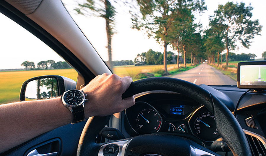 view of road from inside car with steering wheel