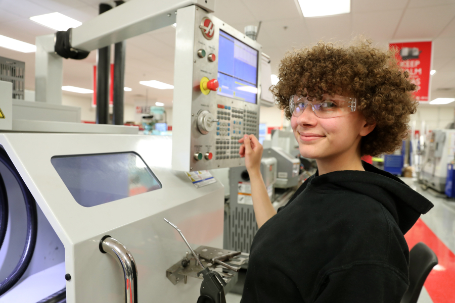 young woman smiling with cnc machine