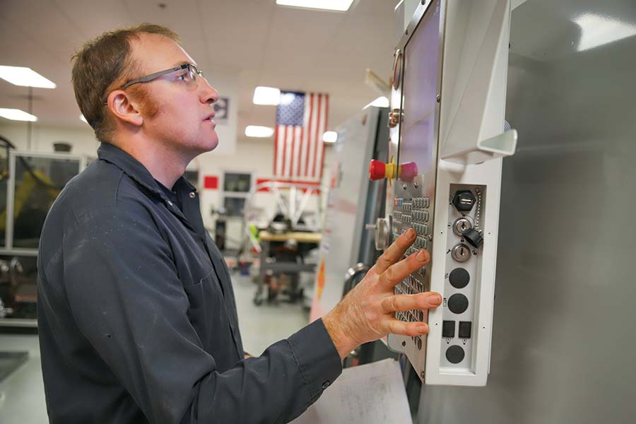 man pressing buttons in factory