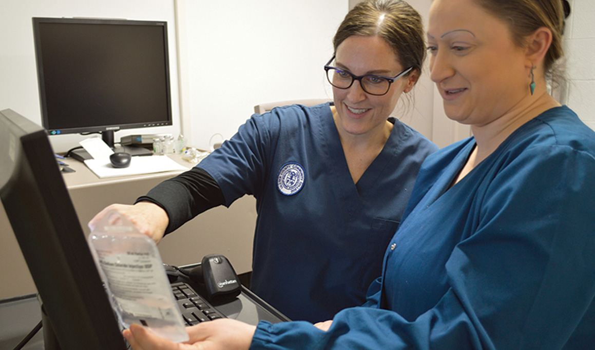 two women in scrubs at work