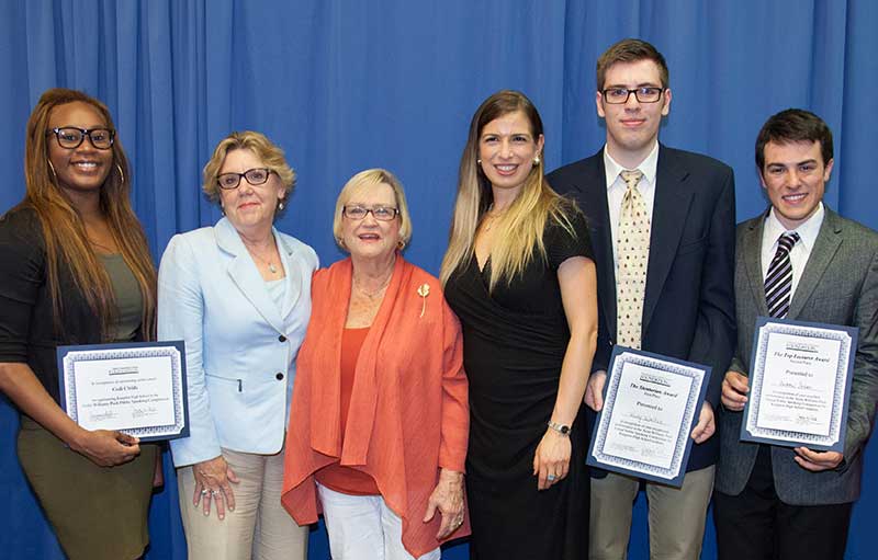 Students holding awards with Anita Williams Peck