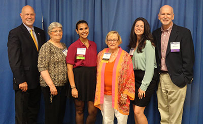 Students holding awards with Anita Williams Peck