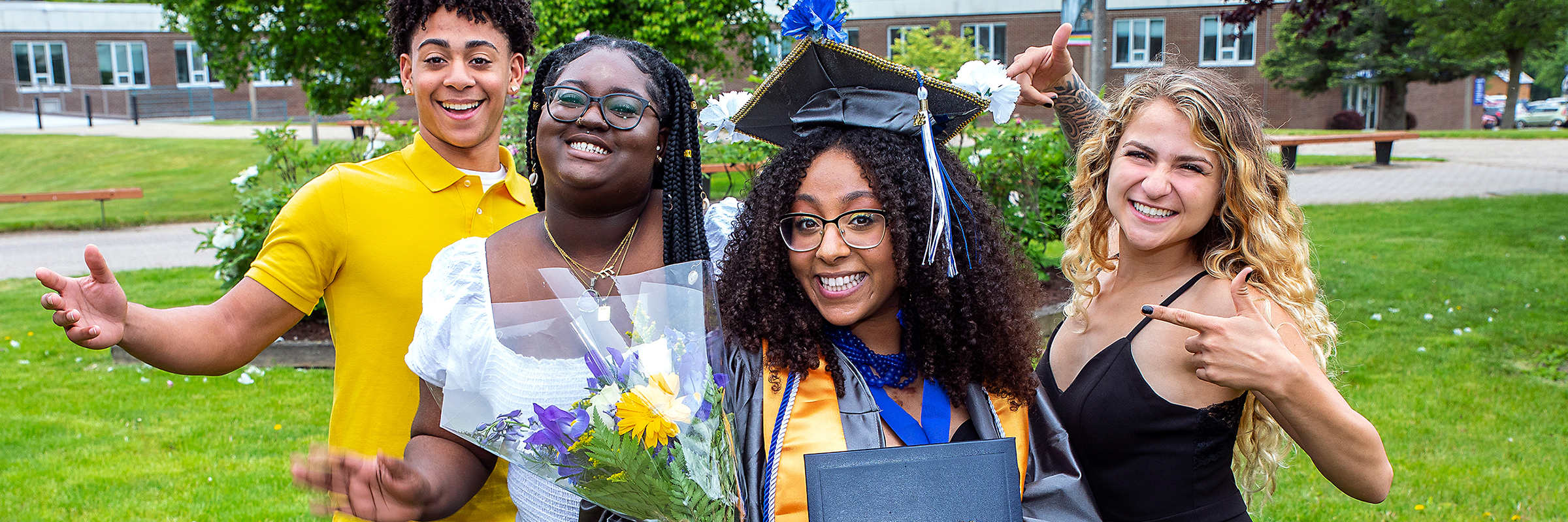 a graduate and 4 friends posing happily