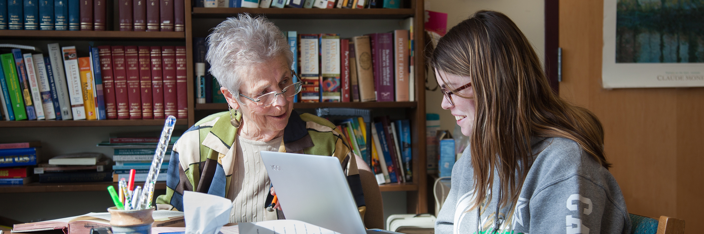 student and instructor with books and laptop