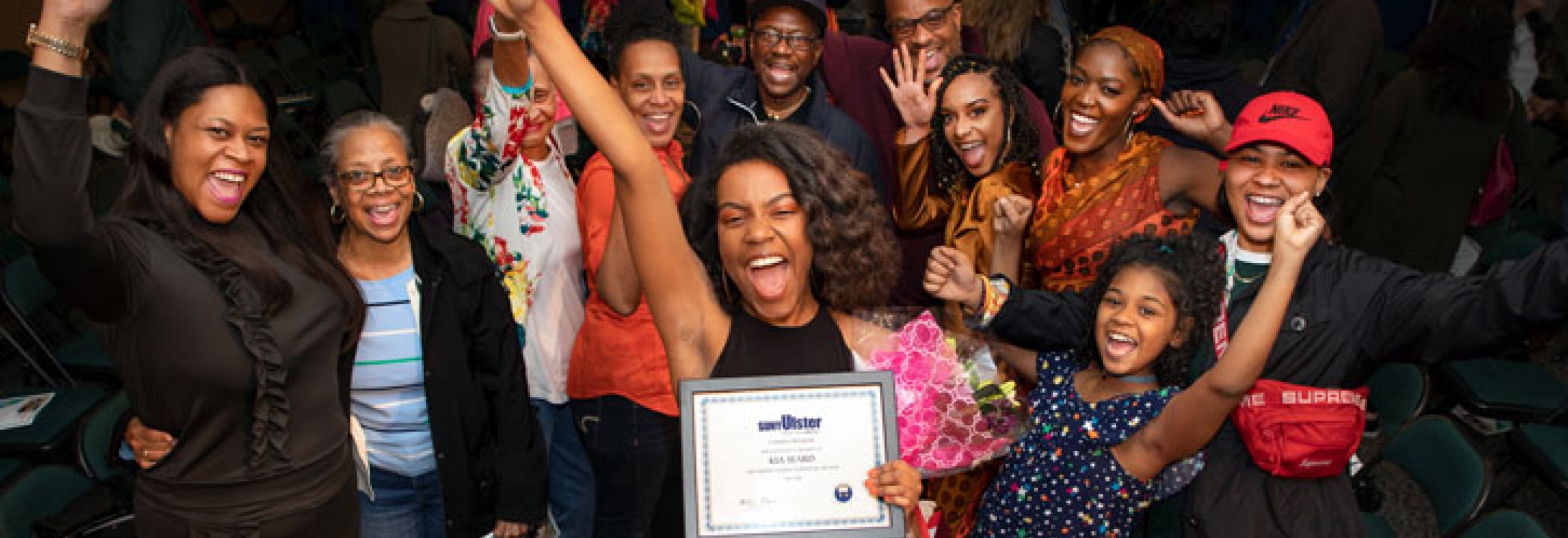 graduate and family celebrating with diploma from SUNY Ulster