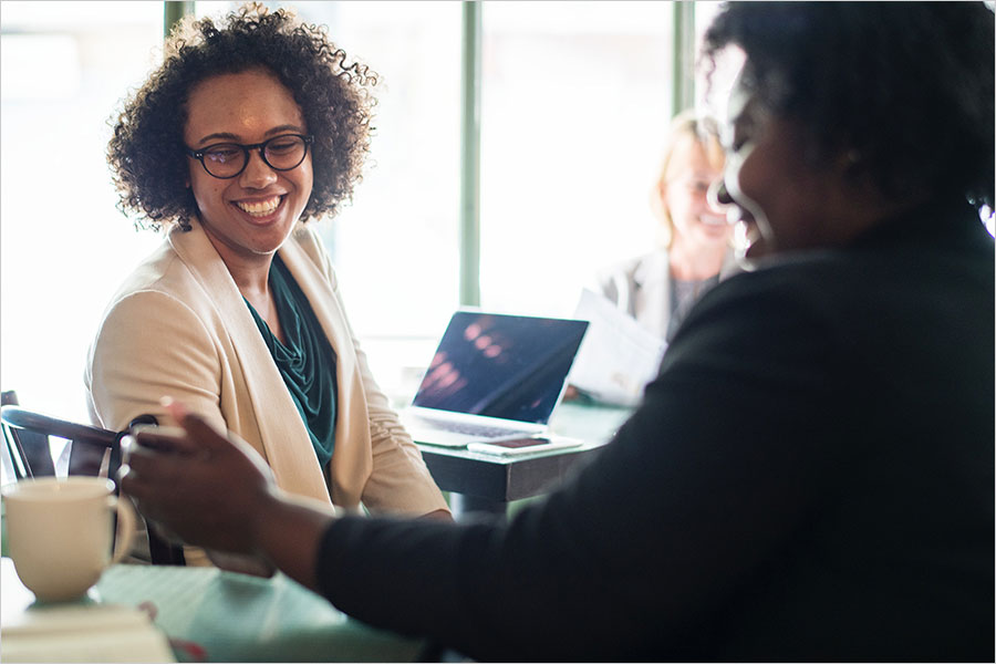 smiling woman with laptop and advisor