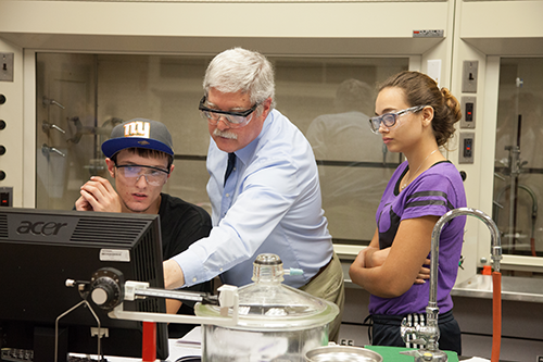 professor and students in safety goggles 